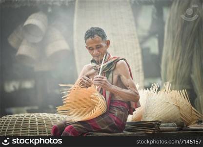 Asia life old man uncle grandfather working in home / Man elderly serious living in the countryside of life rural people in thailand weave bamboo crafts
