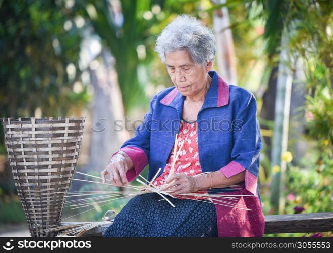 Asia life old woman working in home / Grandmother serious living in the countryside of life rural people in thailand weave bamboo basket crafts
