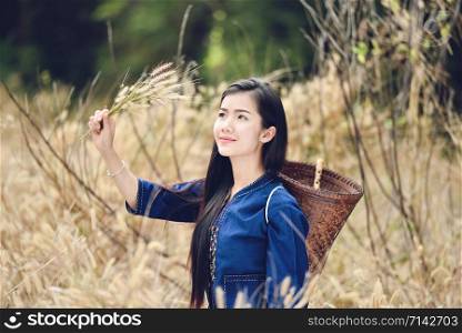 Asia woman farmer in grass field nature / Portrait of beautiful asian young girl happy smile with basket for harvest agriculture in countryside village - dress tribe life