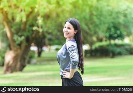Asia Woman keep fit body exercise Stretch the muscles for health in the garden / smiling young girl relax exercise on outdoor happy woman in the park background