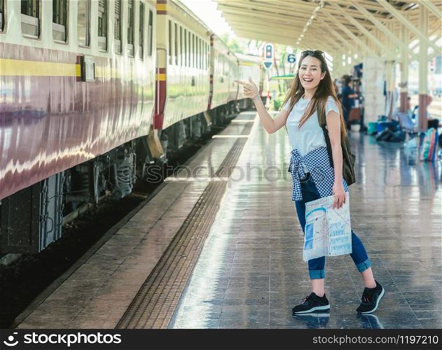 Asia woman Traveller feeling happiness and greeting her friend before go to travel at the train station, Travel and lifestyle concept