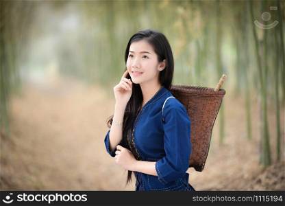Asia women beauty skin in nature bamboo forest / Portrait of beautiful asian young girl happy smile with basket for harvest agriculture in countryside village - dress tribe life