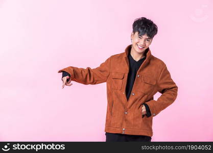 Asian a man handsome young pointing with two hands and fingers to the side eyes looking at camera in love isolated on pink blank copy space studio background.