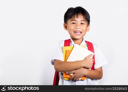 Asian adorable toddler smiling happy wear student thai uniform red pants stand hold or hugging book in studio shot isolated on white background, Portrait little children boy preschool, Back to school