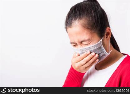 Asian adult woman wearing red shirt and face mask protective against coronavirus or COVID-19 virus or filter dust pm2.5 and air pollution her sneezing use hand close mouth, isolated white background