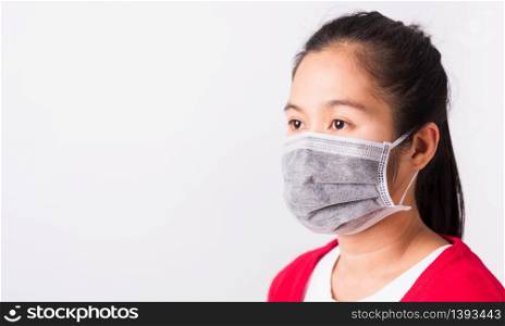 Asian adult woman wearing red shirt and face mask protective against coronavirus or COVID-19 virus or filter dust pm2.5 and air pollution she looking side, studio shot isolated white background