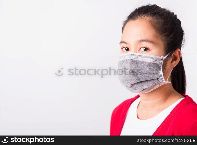 Asian adult woman wearing red shirt and face mask protective against coronavirus or COVID-19 virus or filter dust pm2.5 and air pollution she looking camera, studio shot isolated white background