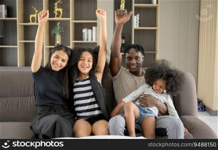 Asian-African American family relaxing, chatting, painting and having fun on vacation in the living room of the house