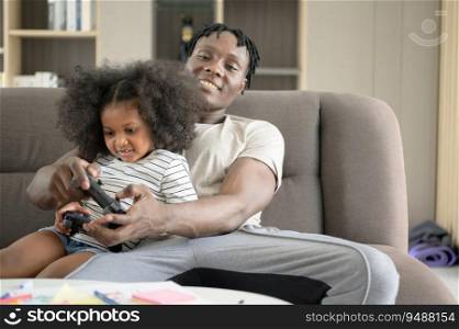 Asian-African American father and son relax by playing computer games in the living room of the house.