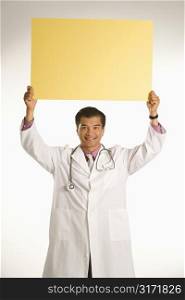Asian American male doctor holding blank sign.