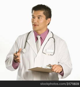 Asian American male doctor holding clipboard talking and gesturing.