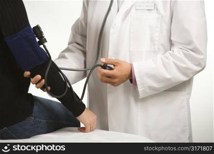 Asian American male doctor testing blood pressure of Caucasian woman.
