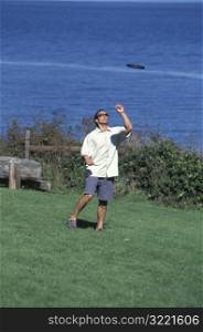 Asian American Man Playing Frisbee Near A Lake