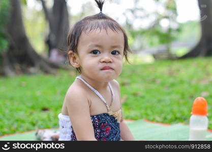 Asian baby girl playing in park.