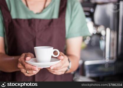 Asian barista serving freshly brewed coffee, stock photo