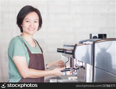 Asian barista smiling and making cup of coffee, stock photo