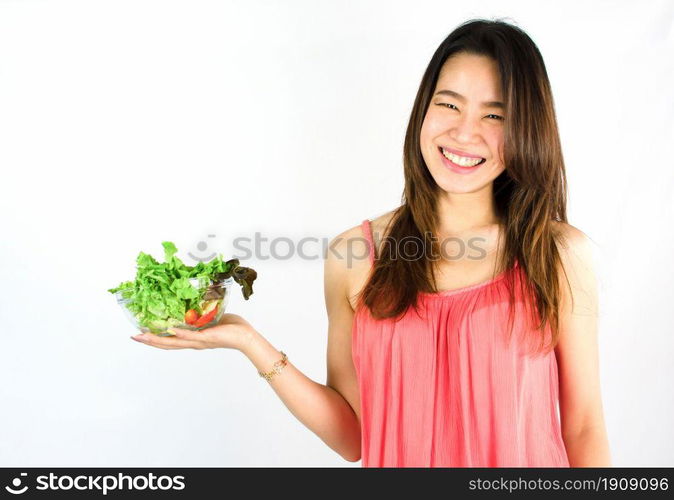 Asian beautiful and healthy woman smiling with happiness, presenting a dish of vegetable and standing on white background