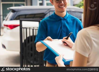 Asian beautiful customer young woman signing delivery in clipboard get her package from service courier man, smiling female signature receipt of delivery package at door front house