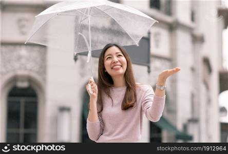 Asian beautiful woman holding umbrella in raining season while standing in city. Lifesyle Concept.