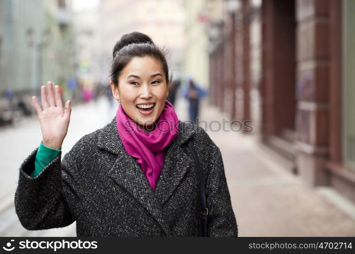 Asian beautiful woman in stylish gray coat on a background of spring street