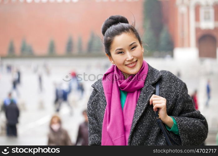 Asian beautiful woman in stylish gray coat on a background of spring street