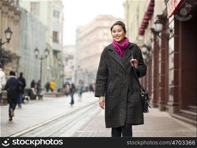 Asian beautiful woman in stylish gray coat on a background of spring street