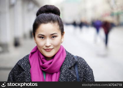 Asian beautiful woman in stylish gray coat on a background of spring street