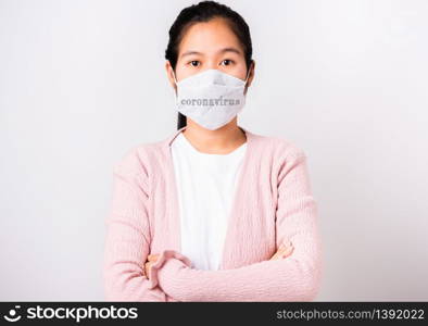Asian beautiful woman wearing protection face mask against coronavirus standing crossed arm, studio shot isolated on white background with copy space, COVID-19 or corona virus concept