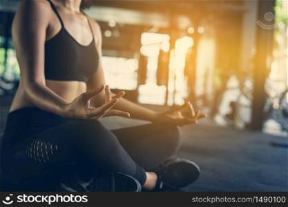 Asian Beautiful women are practicing yoga with meditation Lotus in fitness gym. exercise concept and health for good.