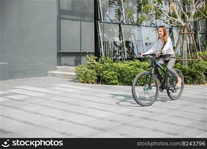 Asian beautiful young businesswoman with helmet riding bicycle go to office work at city street with bicycle in morning, Happy lifestyle woman bike after business work outside building , Eco friendly