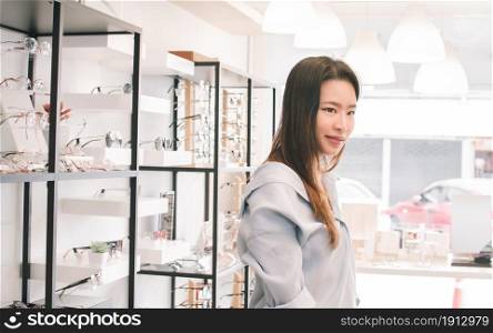 Asian beautiful young woman shopping and trying glasses in store. Sales, Discount and Optical Concept.