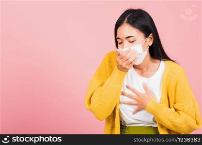 Asian beautiful young woman wearing medical mask protection for prevent infection coronavirus, COVID-19 she cough sneeze, studio shot isolated on pink background, Medical health care concept
