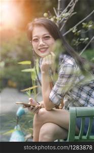 asian beautiful younger woman toothy smiling face and relaxing in garden