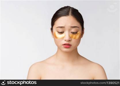 Asian beauty teenager woman care her skin with gold eye masks patches under eyes.. Asian beauty teenager woman care her skin with gold eye masks patches under eyes with worry.