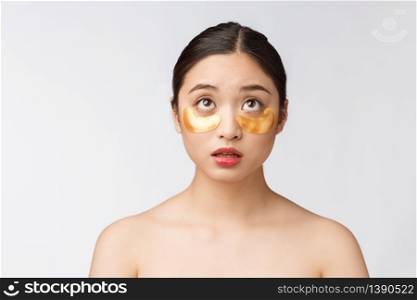 Asian beauty teenager woman care her skin with gold eye masks patches under eyes.. Asian beauty teenager woman care her skin with gold eye masks patches under eyes with worry.