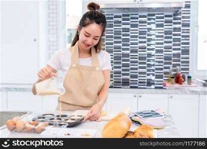 Asian beauty woman cooking and baking cookies in kitchen room on table. Holiday and Happiness concept. People and lifestyles concept. Family and dinner party theme. Girl enjoy making cake with apron