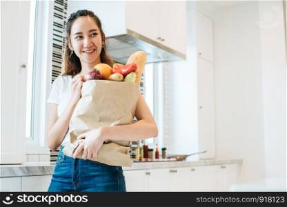 Asian beauty woman holding plenty of ingredients for cooking after shopping at supermarket People and lifestyles concept. Food and meal. Happiness of single woman theme. Dinner party theme.