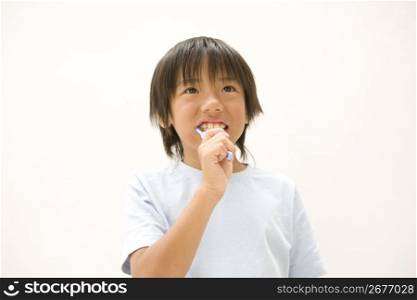 Asian boy brushing his teeth