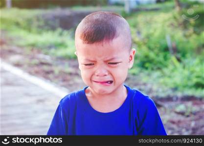 Asian boy crying on the street