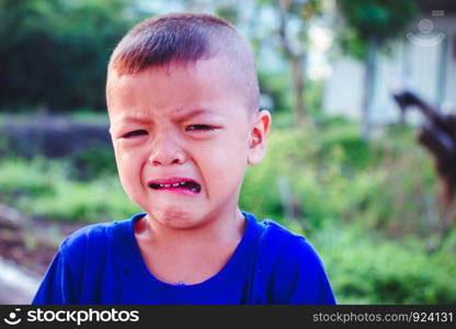 Asian boy crying on the street