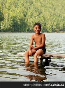 asian boy sitting on stage in lake portrait