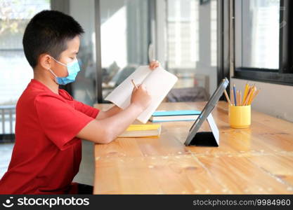 asian boy student wearing face mask studying learning lesson online. remote meeting distance education at home