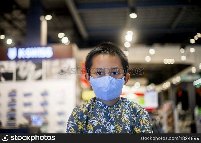 Asian boy wearing a mask in a shopping mall