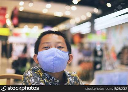 Asian boy wearing a mask in a shopping mall