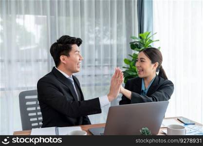 Asian business colleague celebrate successful meeting with high-fives and expressions of happiness in corporate office meeting represent unity success and professional teamwork integrity. Jubilant. Asian business colleague celebrate successful meeting with high-fives. Jubilant