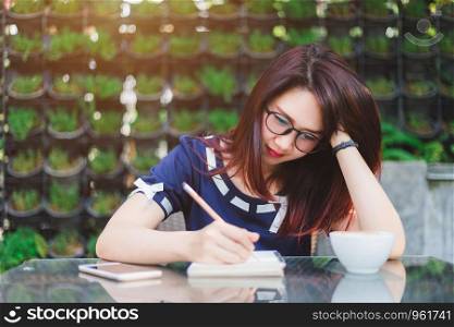 Asian business female working with make a note on office outdoor.