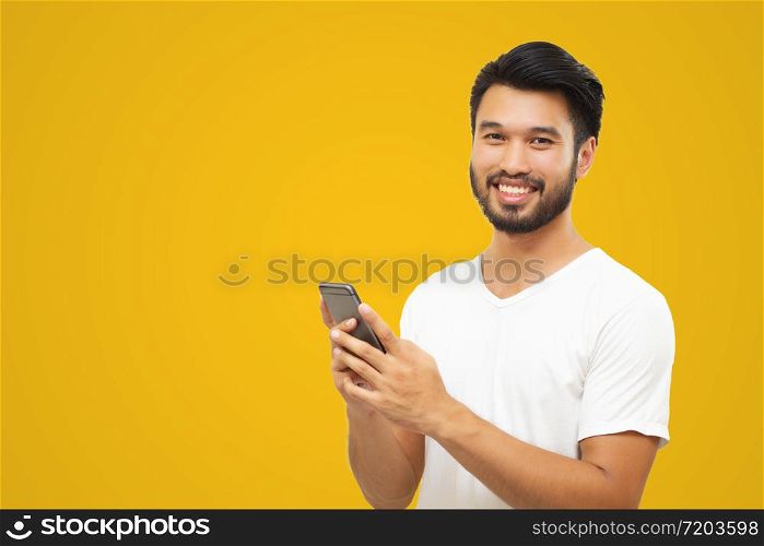 Asian business man handsome man with a mustache, smiling and laughing and using smart phone on yellow background