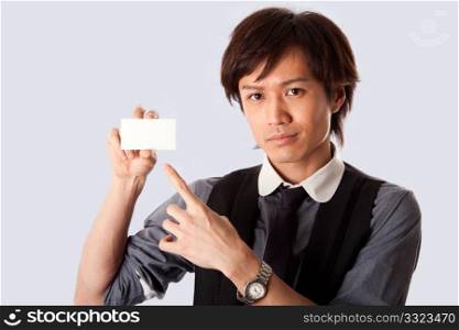 Asian business man holding and presenting a blank white card and pointing at it, isolated.