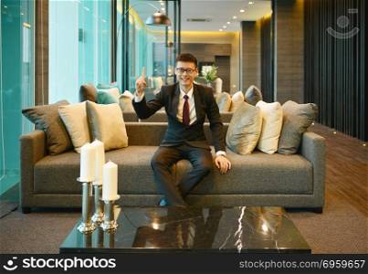 Asian Business man pointing on sofa in luxury condo