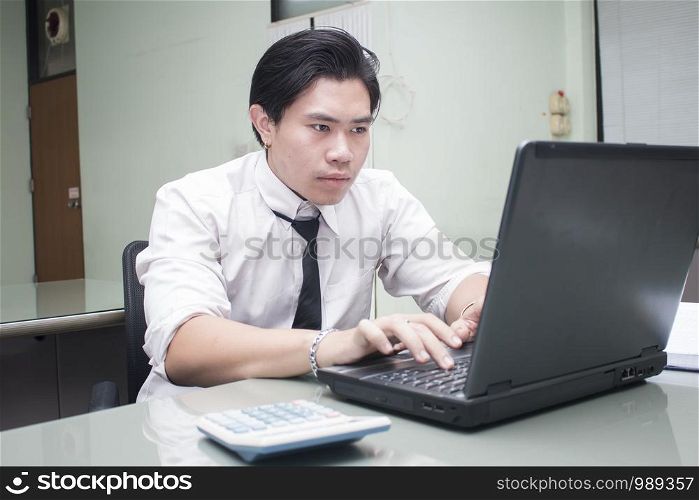 Asian business man working on laptop in office